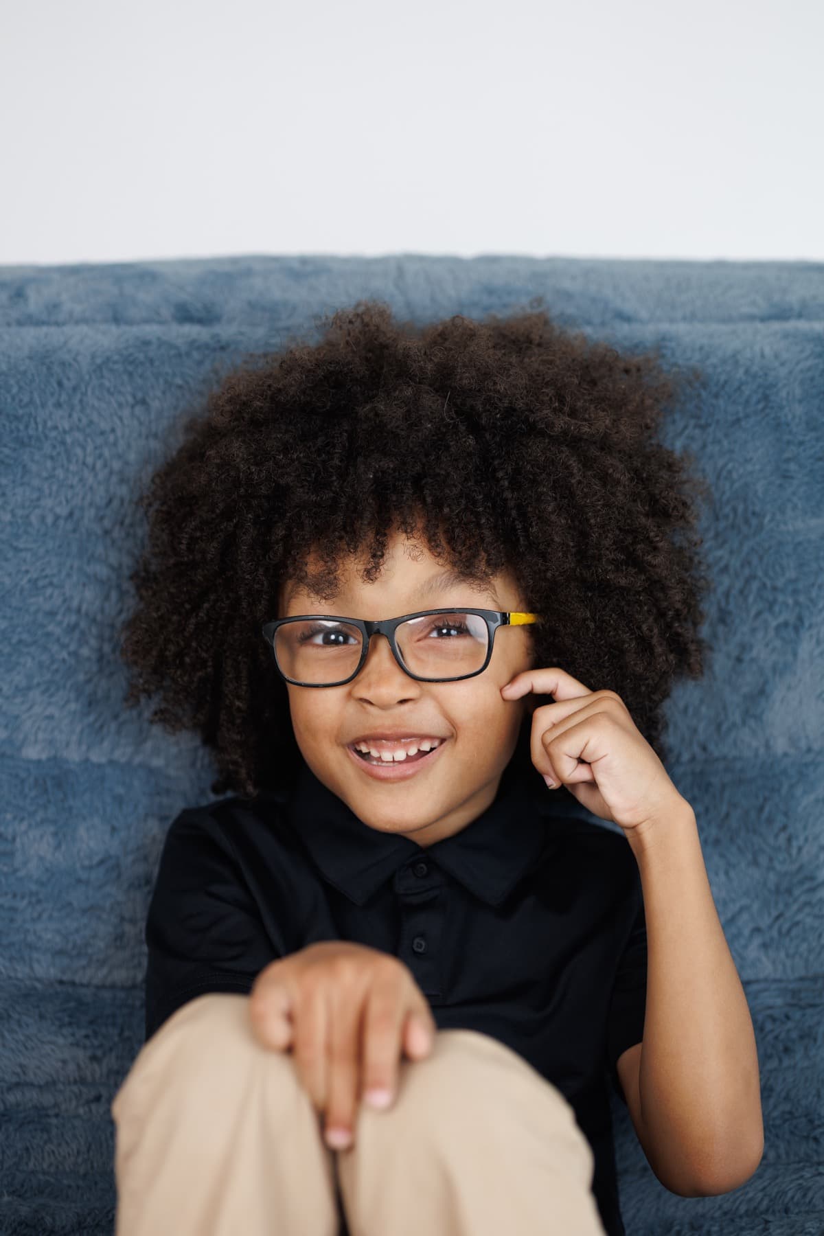 A portrait of the founder's son smiling in glasses.